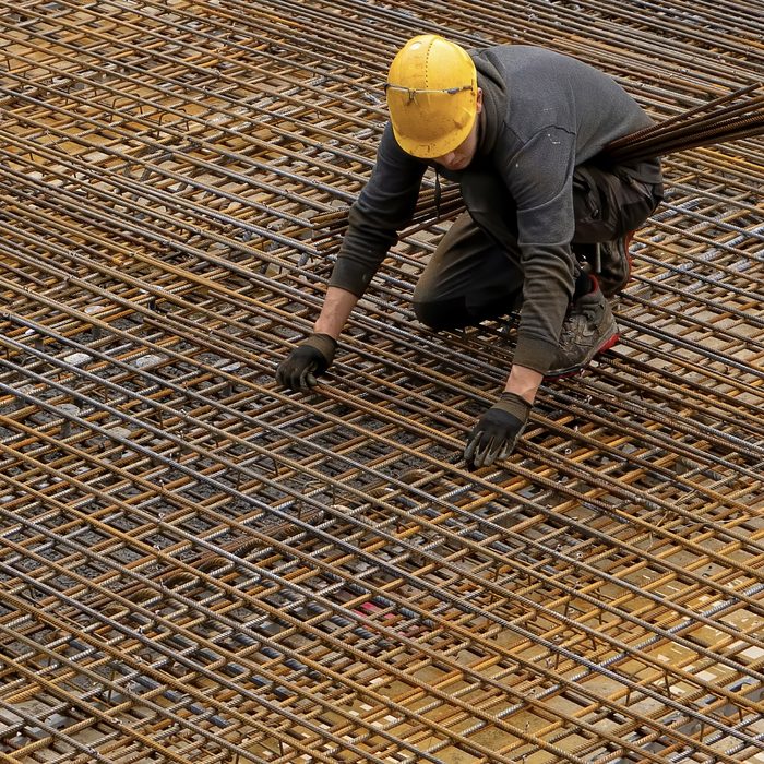 Pekerja merangkai besi tulangan lantai beton